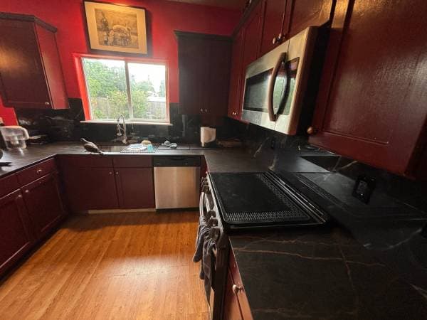 picture of a newly remodeled kitchen with new stainless steel appliances and black granite countertop